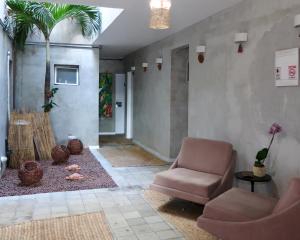 a living room with a chair and a table at Pousada Praia Pajuçara in Maceió