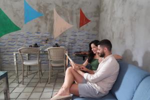 マセイオにあるPousada Praia Pajuçaraのソファに座って本を読む男女