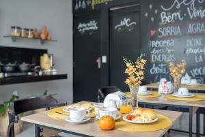 a table with plates of food and oranges on it at Pousada Praia Pajuçara in Maceió