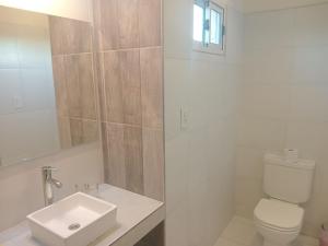 a white bathroom with a sink and a toilet at Casa Tierra Verde Oliva in Ciudad Lujan de Cuyo
