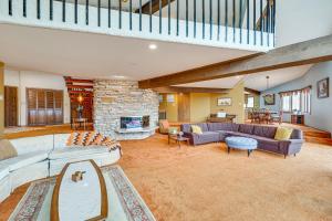 a large living room with couches and a stone fireplace at Eclectic Hubertus Home with Game Room and Fire Pit! in Germantown