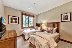 a bedroom with two beds and a tv in it at The PEAK Rubicon 11 - The Ultimate in Lakefront Luxury in South Lake Tahoe +30 photos