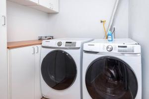 een witte wasmachine naast een witte wasmachine bij Prime Location, Stylish Space: 3BR Home with BBQ in Los Angeles