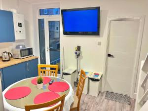 a kitchen with a table and a tv on the wall at Lux En-Suite COOP Arena ManCity Stadium Piccadilly in Manchester