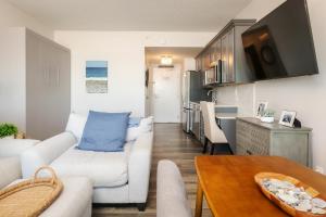 ein Wohnzimmer mit einem weißen Sofa und einem Tisch in der Unterkunft Direct Oceanfront Studio Suite! in Hampton