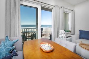 a living room with a table and a view of the ocean at Direct Oceanfront Studio Suite! in Hampton