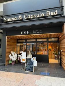 高知的住宿－EN PLUS Sauna and Capsule Bed 男性専用，前面有标志的桑塔和鹰床店