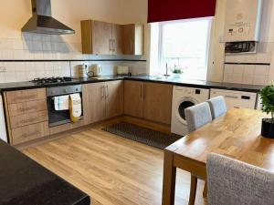 a kitchen with a table and a stove top oven at Homely 3 Bed House Halifax in Exley