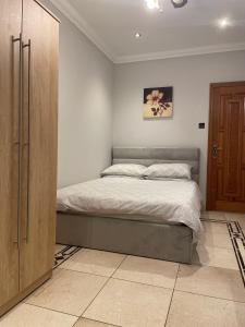 a bedroom with a bed and a wooden cabinet at North London Studio Apartment in London