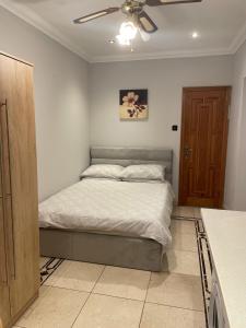 um quarto com uma cama e uma ventoinha de tecto em North London Studio Apartment em Londres