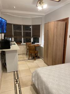 a bedroom with a bed and a kitchen with a table at North London Studio Apartment in London +13 photos