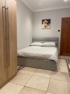 1 dormitorio con 1 cama y armario de madera en North London Studio Apartment en Londres