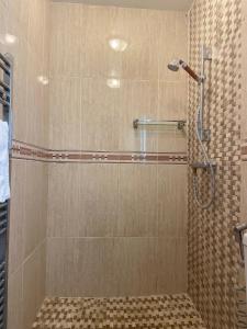 um chuveiro com uma porta de vidro na casa de banho em North London Studio Apartment em Londres