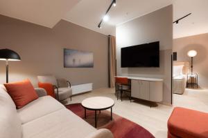 a living room with a couch and a flat screen tv at Scandic Sunnfjord Hotel & Spa in Førde