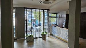 un bureau avec un hall doté de grandes fenêtres et de plantes dans l'établissement Hotel Novi, à Mar del Plata