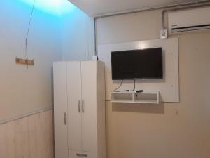 a room with a tv and a white cabinet at Ríos que nos unen in Colonia del Sacramento