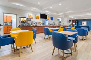 um restaurante com mesas e cadeiras azuis e amarelas em Comfort Inn Near Six Flags St Louis em Pacific