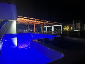 una piscina notturna con illuminazione blu di Pousada do Francês a Ubatuba