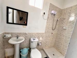 La salle de bains est pourvue de toilettes et d'une télévision murale. dans l'établissement Samanai Wasi Hostel, à Lima