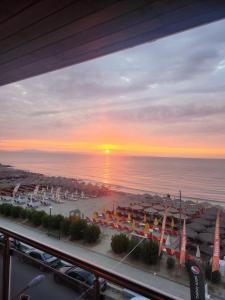 Blick auf einen Strand mit Sonnenuntergang über dem Meer in der Unterkunft Aqua Mare Luxury Apartments in Paralia Katerinis