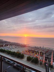 a view of a beach with the sun setting over the ocean at Aqua Mare Luxury Apartments in Paralia Katerinis