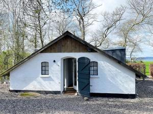 オーベンローにあるThree-Bedroom Holiday home in Bording 4の大きな扉のある白い小さな建物