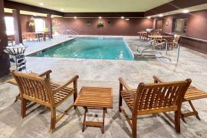a pool with two chairs and a table at Comfort Inn & Suites Chillicothe in Chillicothe