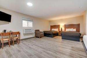 Habitación de hotel con 2 camas y mesa en Suburban Studios near Mesa Verde en Cortez