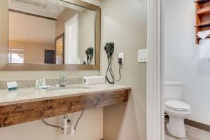 a bathroom with a sink and a mirror and a toilet at Suburban Studios near Mesa Verde in Cortez