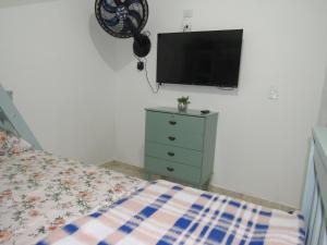 um quarto com uma cama e uma televisão na parede em AEROHOSTEL Brasil em Guarulhos