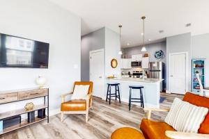 a living room and kitchen with a couch and chairs at Hook Line and Sleeper in Rockport