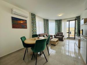 uma sala de estar com uma mesa e cadeiras verdes em HORIZON 6 A Apartment Sveti Vlas em Sveti Vlas