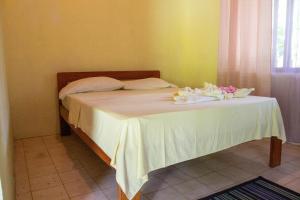 - un lit avec une table et des fleurs dans l'établissement Ventanas Rio, à Carate