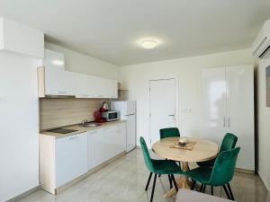 uma cozinha com uma mesa e cadeiras verdes num quarto em HORIZON 6 A Apartment Sveti Vlas em Sveti Vlas
