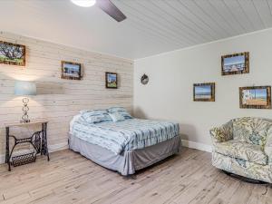 a bedroom with a bed and a chair in it at Oak Cottages 4 in Rockport