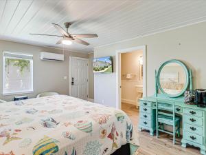 a bedroom with a bed with a blue dresser and a mirror at Oak Cottages 3 in Rockport