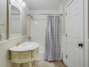 Baño blanco con lavabo y espejo en Oak Cottages 3 en Rockport