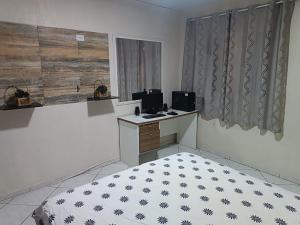 Zimmer mit einem Bett und einem Schreibtisch mit zwei Monitoren in der Unterkunft Espaço Foz in Foz do Iguaçu