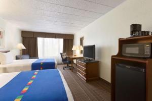 um quarto de hotel com duas camas e uma televisão de ecrã plano em Park Inn By Radisson Sharon em West Middlesex