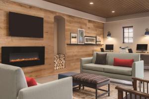 sala de estar con chimenea y TV en Country Inn & Suites by Radisson, Chicago-Hoffman, en Hoffman Estates