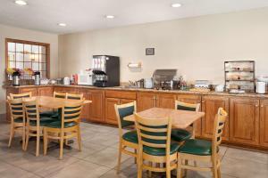 una cocina con armarios de madera, mesa y sillas en Country Inn & Suites by Radisson, Fort Dodge, IA, en Fort Dodge