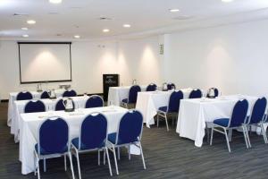 una sala de conferencias con mesas blancas y sillas azules en Radisson Hotel Decapolis Miraflores en Lima