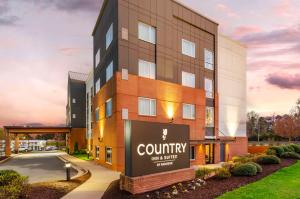 a building with a sign that reads i county my services at Country Inn & Suites by Radisson, Charlottesville-UVA, VA in Charlottesville