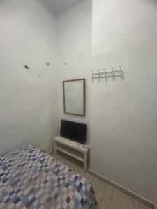 um quarto com uma cama, um espelho e uma televisão em SAN Rafael em Barcelona