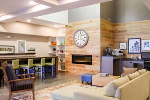 a living room with a fireplace and a clock on a wall at Country Inn & Suites by Radisson, Chester, VA in Chester