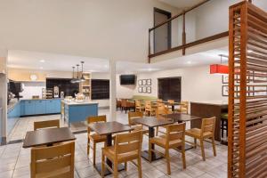 a dining room and kitchen with tables and chairs at Country Inn & Suites by Radisson, Dahlgren-King George, VA in Dahlgren