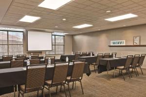 a conference room with tables and chairs and a screen at Country Inn & Suites by Radisson, Petersburg, VA in Petersburg