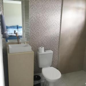 a bathroom with a toilet and a sink and a mirror at Aconchego das flores in Campos do Jordão