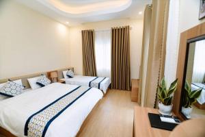 Kon Von Kla的住宿－Vân Dương hotel，酒店客房设有两张床和一张桌子。