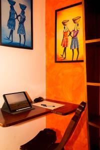 a desk with a laptop computer and a painting of women at Home sweet home in Santa Maria